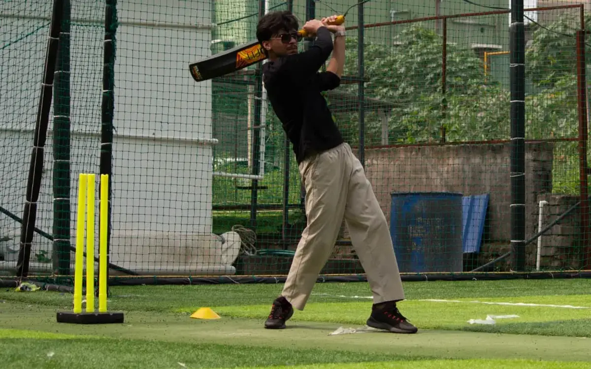 A batter mid-swing in a cricket net during the post-run sports at AV Sports Arena