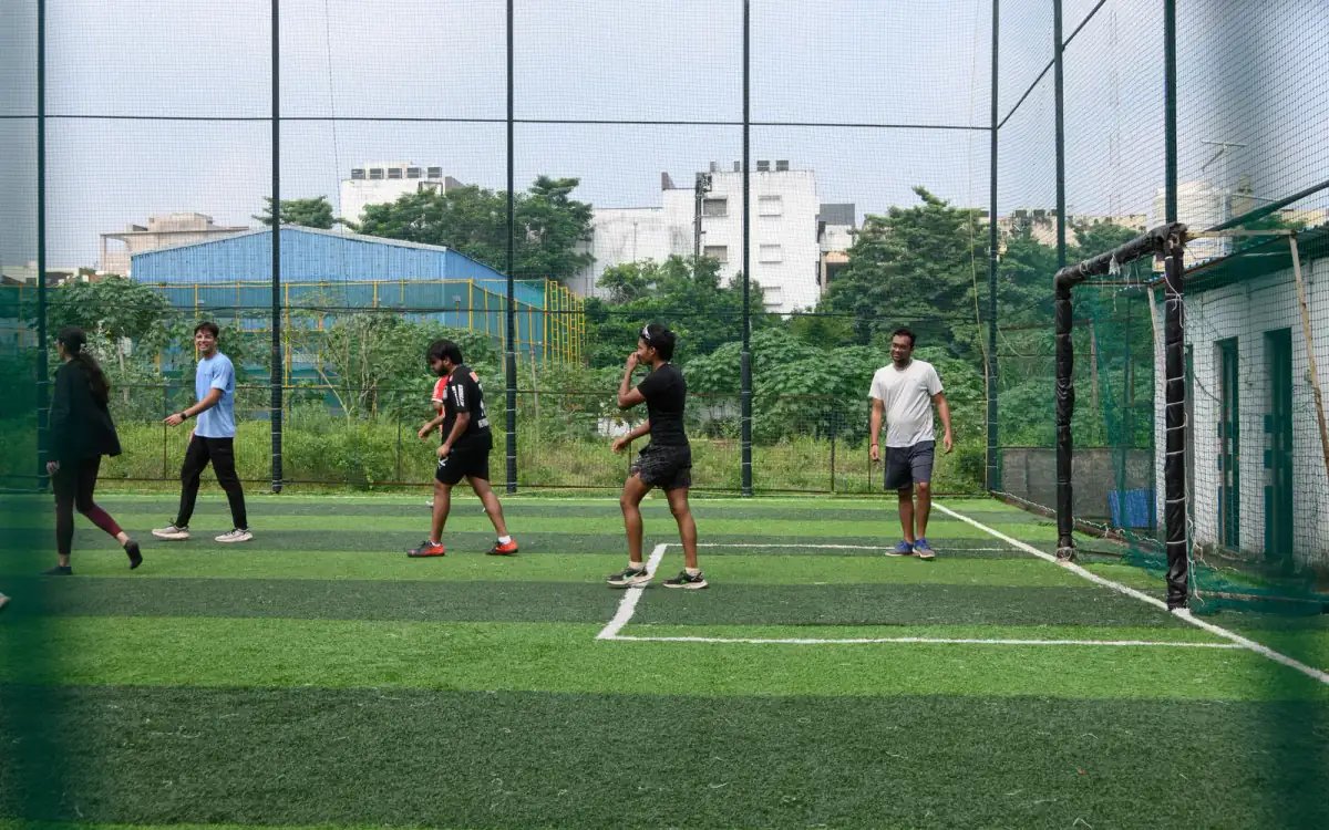 Participants walking and playing football on the turf at AV Sports Arena after the run