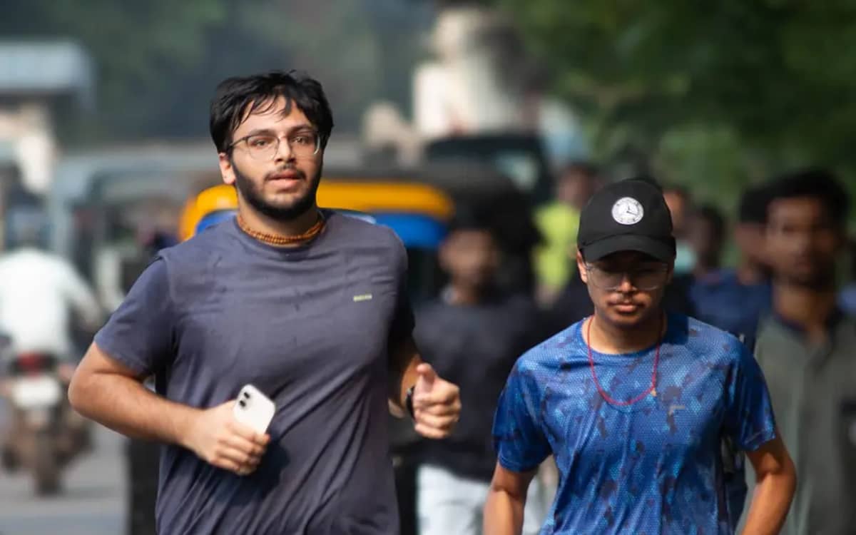 Two Verve Run Club runners jogging side by side on a road during a community run