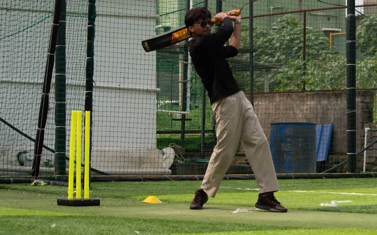 A player in mid-swing at cricket during the Verve Turf Social post-run games, on an artificial turf ground behind a net